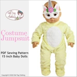 May include: A PDF sewing pattern for a 15 inch baby doll costume jumpsuit. The doll is wearing a yellow jumpsuit with a white patch and a unicorn mask.
