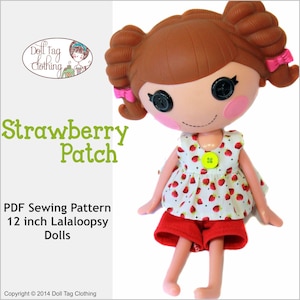 May include: A PDF sewing pattern for a 12 inch Lalaloopsy doll outfit. The outfit is a white and red strawberry print dress with a yellow button and red shorts. The doll has brown hair in pigtails with pink bows.