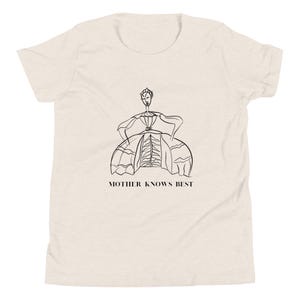 Puede incluir: Una camiseta blanca con un dibujo de línea negra de una mujer con un vestido. El texto "MOTHER KNOWS BEST" está impreso debajo del dibujo.