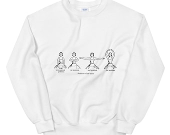 Puede incluir: Una sudadera blanca con una ilustración negra de una bailarina que demuestra las cinco posiciones básicas de los brazos en ballet. El texto debajo de la ilustración dice "Posiciones de los brazos" y etiqueta cada posición: "posición preparatoria", "1ª posición", "2ª posición", "3ª posición" y "5ª posición".