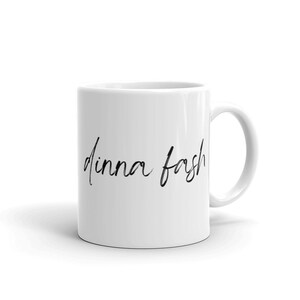 May include: White ceramic coffee mug with black handwritten text that reads "dinna fash".