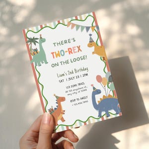 May include: A rectangular birthday invitation card featuring colourful illustrations of four dinosaurs wearing party hats, a palm tree, balloons, and bunting. The text reads: THERE'S TWO-REX ON THE LOOSE! Liam's 2nd Birthday, SAT 1 JULY 23 | 2PM.