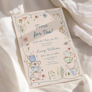May include: A baby shower invitation with the text "Time for Tea!" and floral illustrations. The invitation features a stack of teacups and a teapot, with the details of the event, including the date, time, and location.