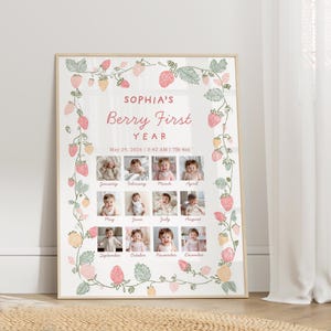 May include: A framed print featuring a baby's first year milestones. The design includes a strawberry vine border and the text "SOPHIA'S Berry First YEAR." Twelve small photos are arranged around the text, with the months labeled below. The date and time of birth are also included.