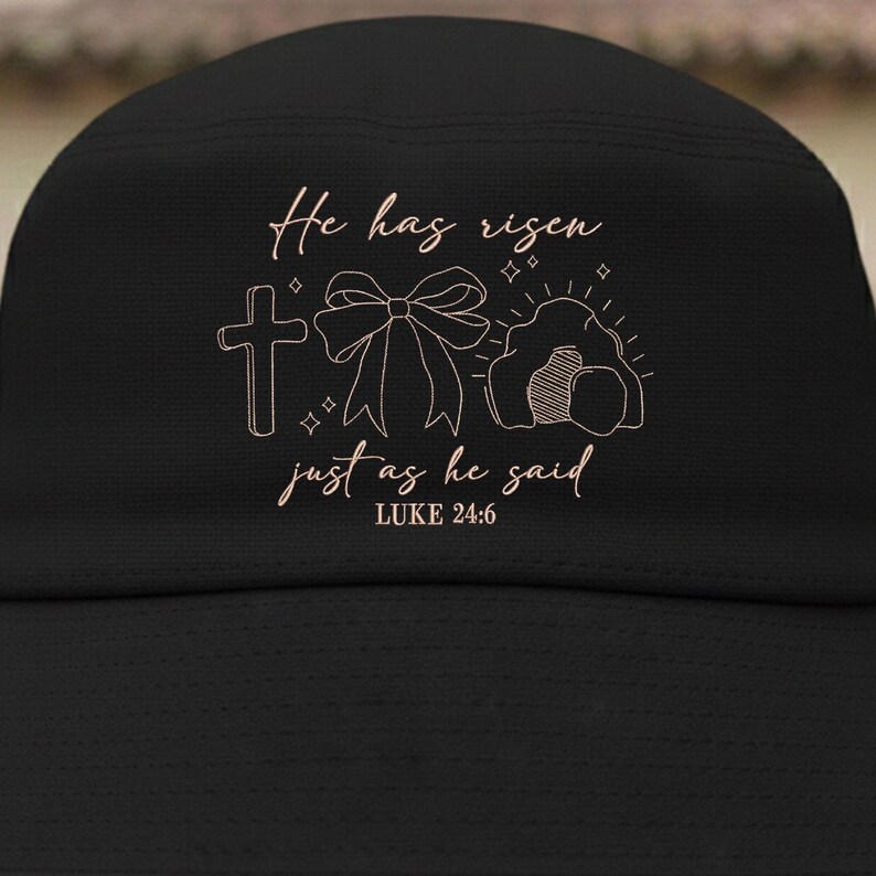 May include: Black bucket hat with a light brown graphic. The graphic includes a cross, a bow, and an empty tomb with the text "He has risen just as he said Luke 24:6".