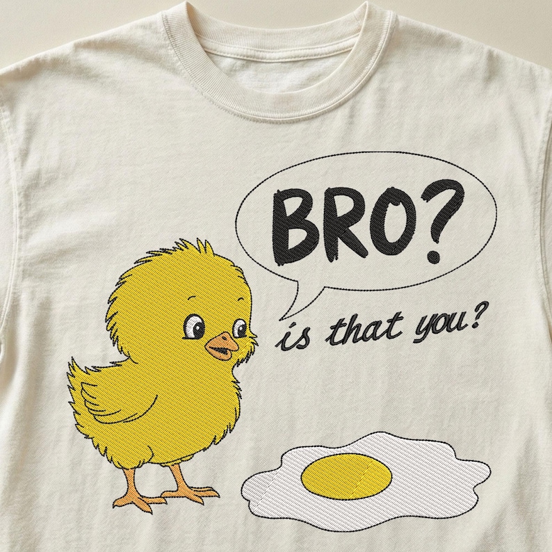 May include: Cream-colored t-shirt featuring an embroidered yellow chick with the text "BRO? is that you?" in a speech bubble. An embroidered fried egg is also present. The design is whimsical and playful.