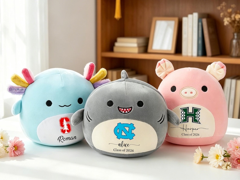 May include: Three plush toys: a light blue axolotl, a gray shark, and a pink pig. Each has a logo and name. The axolotl has a red tree logo and the name "Roman". The shark has a blue logo and the name "alice". The pig has a green logo and the name "Harper".