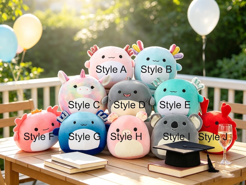 May include: A collection of plush toys in various styles and colors, including pink, blue, and gray. Each plush has a unique design, such as an axolotl, shark, and koala. The toys are arranged on a wooden table with books and a graduation cap.