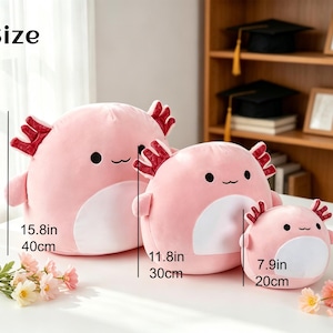 May include: Three pink axolotl plush toys of varying sizes. The largest is 15.8 inches (40cm) tall, the middle one is 11.8 inches (30cm), and the smallest is 7.9 inches (20cm). Each has a white belly, red gills, and a smiling face.