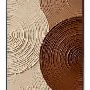 May include: Abstract wall art in a black frame. The artwork features a textured surface with three overlapping circular shapes in shades of cream, tan, and brown. The circles have a spiral pattern, creating a sense of depth and movement. The piece is a modern, minimalist design.