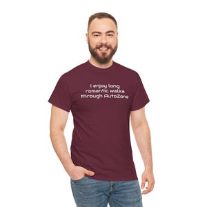 May include: Maroon t-shirt with the text "I enjoy long romantic walks through AutoZone" in white. The shirt is a solid color and has a crew neck. The shirt is made of a soft, comfortable material.