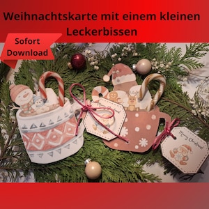 May include: Christmas-themed paper cutouts in the shape of mugs and a Santa hat, each holding a candy cane. The mugs feature snowman and gingerbread man designs, with "Merry Christmas!" tags. The text "Weihnachtskarte mit einem kleinen Leckerbissen" is visible.