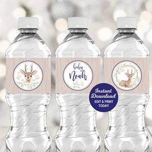 May include: Three water bottles with labels featuring a fawn with antlers and floral accents. The labels are beige with a woodgrain texture and blue accents. One label says "Baby Noah". The text "Instant Download EDIT & PRINT TODAY!" is on a blue tag.