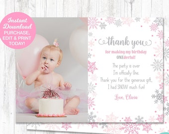 May include: Pink and gray thank you card with a snowflake design. The card has a photo of a baby girl with a birthday cake and a pink balloon. The text on the card reads "Thank you for making my birthday ONEderful! The party is over I'm officially One. Thank you for the generous gift, I had SNOW much fun! Love, Olivia."
