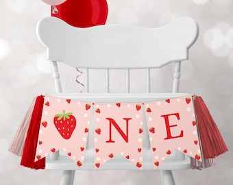 Puede incluir: Bandera de silla alta rosa y roja con la palabra "ONE" en letras rojas y un diseño de fresa. La bandera tiene borlas rojas y rosas en cada extremo.