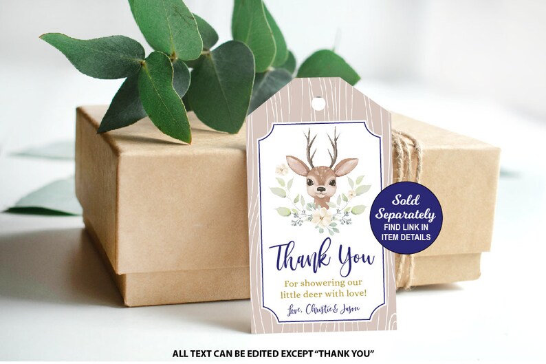 May include: An illustration of a brown and white deer with floral accents on a beige woodgrain background. The text "Thank You" is printed in purple with the words "For showering our little deer with love!" and "Love, Chastie & Jagon" printed below. A blue circle with the text "Sold Separately FIND LINK IN ITEM DETAILS" is in the top right corner.