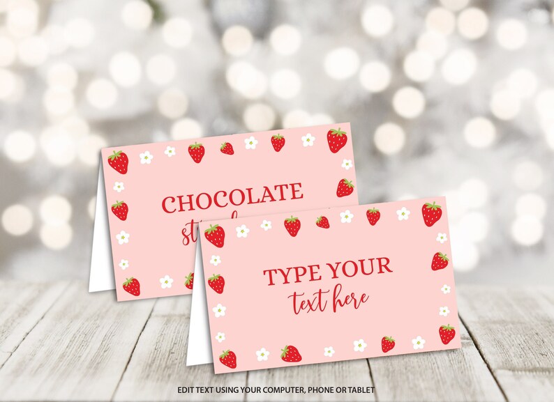 Puede incluir: Dos tarjetas de mesa imprimibles de color rosa con un borde de fresas y flores blancas. La tarjeta superior dice "Fresas con chocolate". La tarjeta inferior dice "Escribe tu texto aqu&iacute;".
