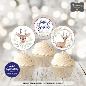 May include: Cupcakes with toppers featuring a deer theme. The toppers have deer illustrations and the text "little Buck". The cupcakes are decorated with white frosting. The image also includes the text "Sold Separately, Edit & Print Today".