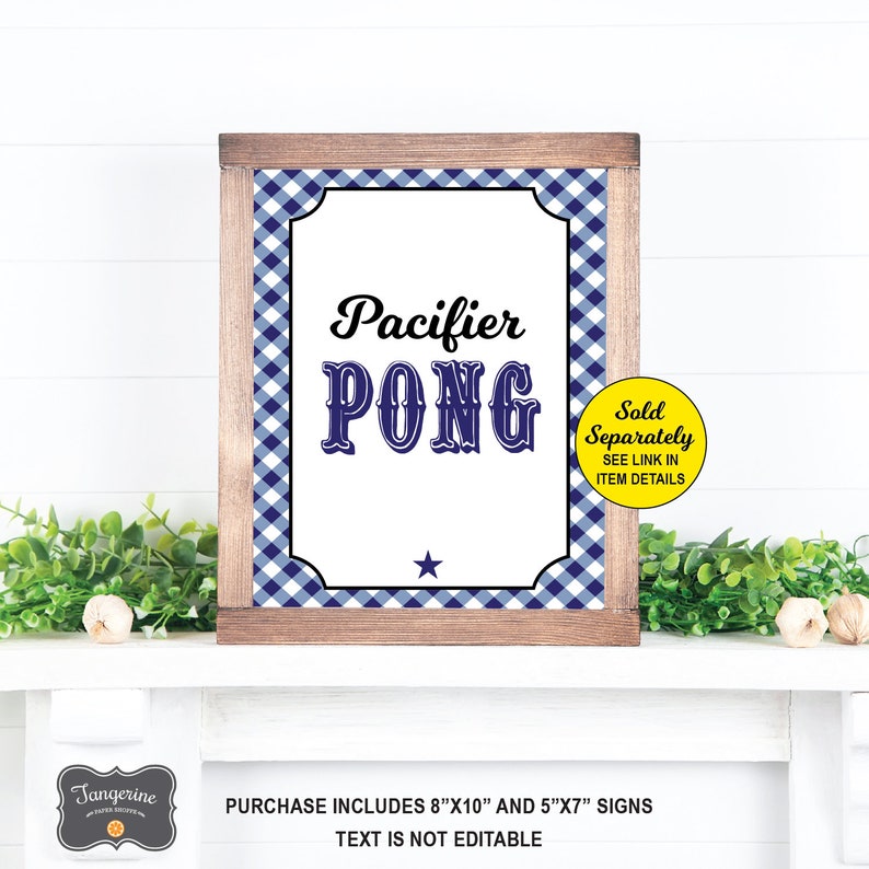 Op de afbeelding: Een bord met een blauw-wit geruite achtergrond en de tekst "Pacifier Pong" in zwarte en blauwe letters. Het bord is ingelijst met hout en heeft een gele cirkel met de tekst "Apart verkocht ZIE LINK IN ARTIKELDETAILS". Het bord is 8 inch bij 10 inch en 5 inch bij 7 inch.