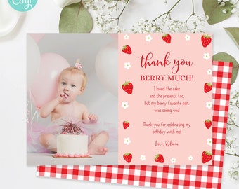 May include: Pink and red thank you card with a strawberry theme. The card has a photo of a baby girl with a cake and balloons. The text on the card reads "Thank you Berry Much! I loved the cake and the presents too, but my berry favorite part was seeing you! Thank you for celebrating my birthday with me. Love, Olivia."