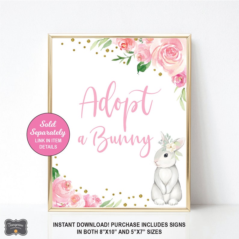 May include: A pink and white sign with a floral border and gold glitter. The sign says "Adopt a Bunny" and includes a watercolor illustration of a gray bunny with a flower crown. The sign is available in 8x10 inches and 5x7 inches.