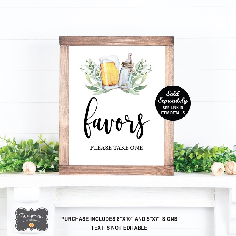 May include: A white sign with a brown wooden frame, featuring a watercolor illustration of a beer mug and a baby bottle with green leaves. The sign reads "favors" in black cursive font and "Please take one" in black text. The sign also includes the text "Sold Separately SEE LINK IN ITEM DETAILS". The sign is on a white shelf with green plants.