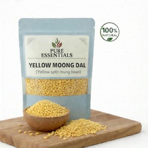May include: A package of yellow moong dal (yellow split mung beans) with a wooden bowl and a pile of the beans on a wooden cutting board. The package has the text "Pure Essentials" and "100% Natural".