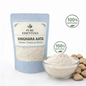 May include: A light blue pouch of "SINGHARA AATA (Water Chestnut Flour)" next to a clear glass bowl filled with flour and a pile of water chestnuts. The pouch and bowl are labeled "100% NATURAL".