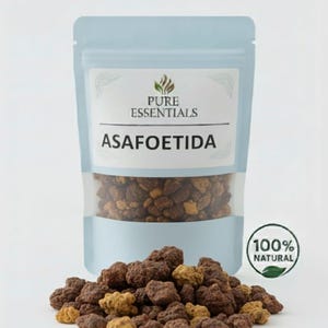 May include: A light blue pouch labeled "PURE ESSENTIALS" containing asafoetida, with a clear window showing the contents. The product is accompanied by a pile of brown and tan asafoetida granules. A "100% NATURAL" seal is visible.