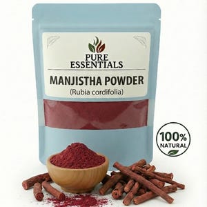 Könnte beinhalten: Ein hellblauer Beutel mit der Aufschrift "Pure Essentials" und "Manjistha Powder" und "(Rubia cordifolia)". Eine Holzschale mit rotem Pulver, rote Stöcke und ein "100% Natural"-Siegel sind im Bild.