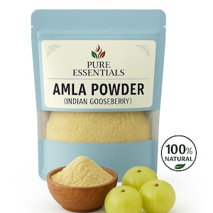 Könnte beinhalten: Ein hellblauer Beutel mit Amla-Pulver (indische Stachelbeere) mit einer Holzschale mit Pulver und drei grünen Stachelbeeren. Die Verpackung trägt die Aufschrift "Pure Essentials" und "100% Natural".