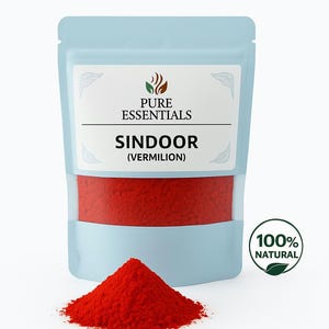 May include: A light blue pouch labelled "PURE ESSENTIALS" containing red sindoor (vermilion) powder. A small pile of the red powder sits in front of the pouch. A green and white circular sticker reads "100% NATURAL".