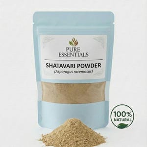 Puede incluir: Una bolsa azul claro con la etiqueta "PURE ESSENTIALS" que contiene polvo de Shatavari (Asparagus racemosus). Un mont&oacute;n de polvo marr&oacute;n se encuentra frente a la bolsa. Un sello verde y blanco "100% NATURAL" est&aacute; a la derecha.