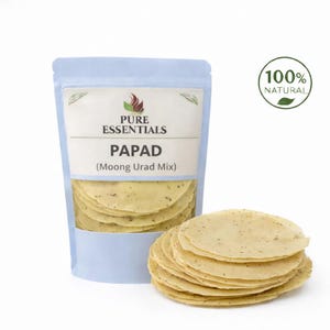 May include: A light blue pouch of Pure Essentials Papad (Moong Urad Mix) with a stack of round, thin, yellow-beige papadums. The packaging includes the text "100% Natural" and the brand name.
