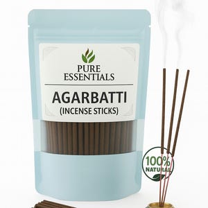 May include: A light blue pouch of Agarbbati incense sticks with the Pure Essentials logo. Several brown incense sticks are burning, emitting white smoke. A gold-coloured incense holder is visible, along with a "100% Natural" sticker.