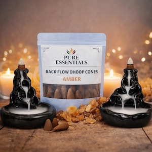 May include: A display of backflow dhoop cones with amber scent. Two black ceramic incense burners with smoke cascading down are on either side of a bag of cones. The bag reads "Pure Essentials" and "Back Flow Dhoop Cones Amber".