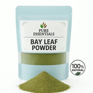May include: A light blue pouch labeled "Pure Essentials" containing bay leaf powder. A small pile of green bay leaf powder sits in front of the pouch. A circular sticker reads "100% Natural".