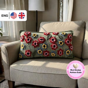 Op de afbeelding: Een rechthoekig gehaakt kussen met een bloemenontwerp. Het kussen heeft rode, gele en blauwe bloemen op een groene achtergrond. Het kussen ligt op een beige bank. De afbeelding bevat ook de tekst "Plush Crochet Pattern" en "Best Sewing Pattern Guide".