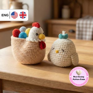 Puede incluir: Dos figuras de pollo de ganchillo sobre una mesa de madera. Una es una cesta con una cabeza de pollo y huevos coloridos. La otra es un pollo pequeño con un lazo azul. Las figuras están hechas a mano y tienen un diseño lindo y caprichoso.