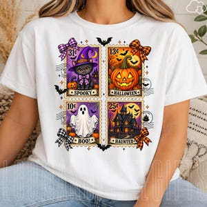 May include: A white t-shirt featuring a graphic of four postage stamps with Halloween themes. The stamps depict a black cat in a purple hat, a jack-o'-lantern, a white ghost, and a haunted house, with text reading SPOOKY, HALLOWEEN, BOO, and HAUNTED.