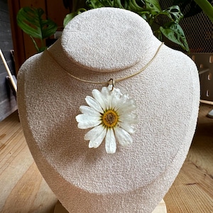 May include: A white ceramic mug with a black handle and the text "But First, Coffee" in a black, handwritten-style font. The mug is on a white surface.