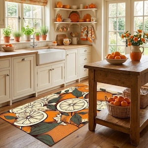 Puede incluir: Interior de cocina con una alfombra con diseño de cítricos. La alfombra tiene un patrón de rodajas de naranja, flores y hojas verdes. La cocina tiene gabinetes de madera, un fregadero de granja y una mesa de madera con naranjas en una canasta.