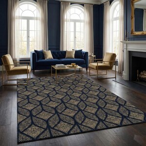 May include: A navy blue and beige patterned area rug in a living room setting. The rug features a repeating geometric design of interconnected shapes. The room includes a blue sofa, gold chairs, and large windows.