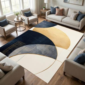May include: A large area rug with an abstract design. The rug features navy blue, gold, and cream-colored geometric shapes. The rug is placed on a hardwood floor in a living room setting, surrounded by furniture.
