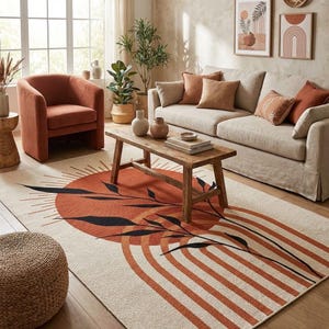 May include: A living room scene featuring a beige sofa with orange pillows, an orange armchair, and a wooden coffee table. A large area rug with an orange sunburst and black leaf design is the focal point, complemented by decorative vases and framed art.
