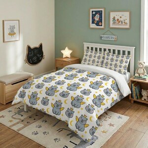 A colorful kids' bedroom showing a whimsical angel capybara-themed duvet cover and matching pillowcases, styled with a star-shaped lamp, rocket poster, and wooden floor.