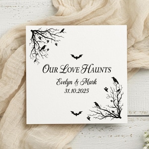 Peut inclure: Une carte carrée blanche avec des illustrations à l'encre noire d'arbres dénudés, de corbeaux, de fantômes et de chauves-souris. Le texte indique Our Love Haunts, Evelyn & Mark, et 31.10.2025. Les arbres occupent les coins opposés de la carte.