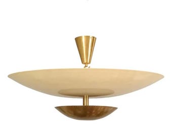 May include: A mid-century modern ceiling light fixture. The fixture features a large, cream-colored, saucer-shaped shade, a smaller, bronze-colored bowl-shaped shade, and a gold-colored cone-shaped top. The light hangs from a gold-colored rod.