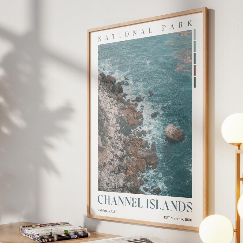 May include: A framed print depicting the Channel Islands National Park coastline. The image shows a rocky shore meeting turquoise water. The text "NATIONAL PARK" and "CHANNEL ISLANDS" are displayed at the top and bottom of the print.