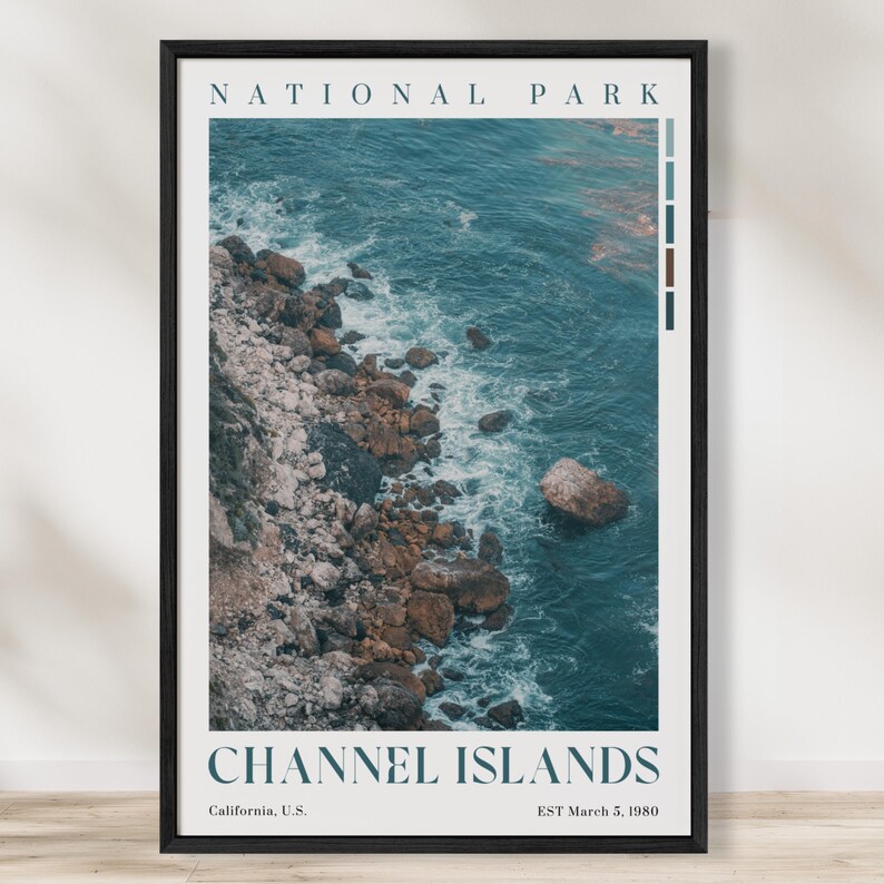 May include: A framed print depicting the Channel Islands National Park coastline. The image shows a rocky shore meeting the turquoise sea. The words "NATIONAL PARK" and "CHANNEL ISLANDS" are printed at the top and bottom, with location and date details included.
